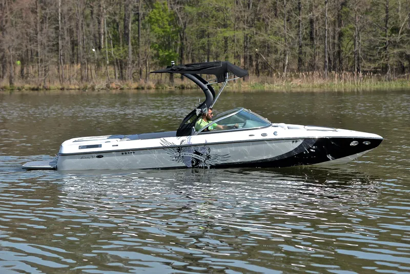 Slide: The Image of 2012 Centurion ELITE C4 boat cruising on a calm lake with forest backdrop. - 7