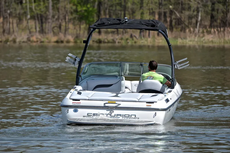 Slide: The Image of 2012 Centurion ELITE C4 boat on a calm lake with a person steering. - 8