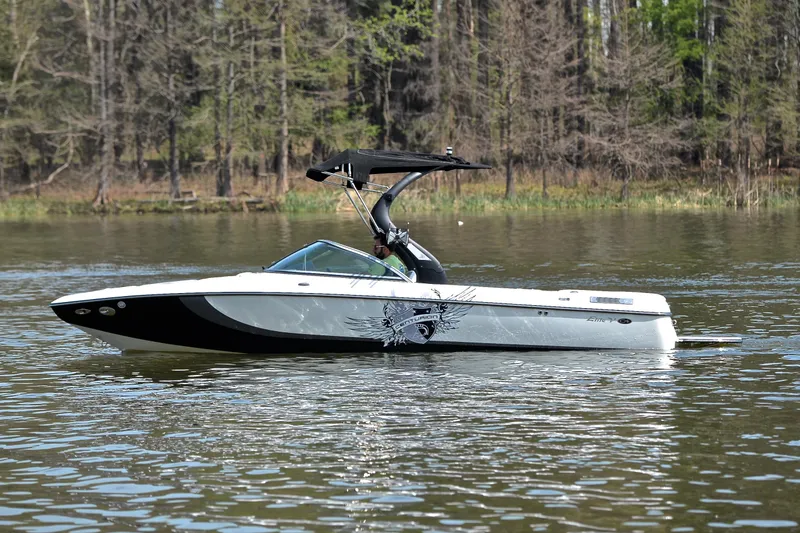 Slide: The Image of 2012 Centurion ELITE C4 boat on a calm lake with forest background. - 9