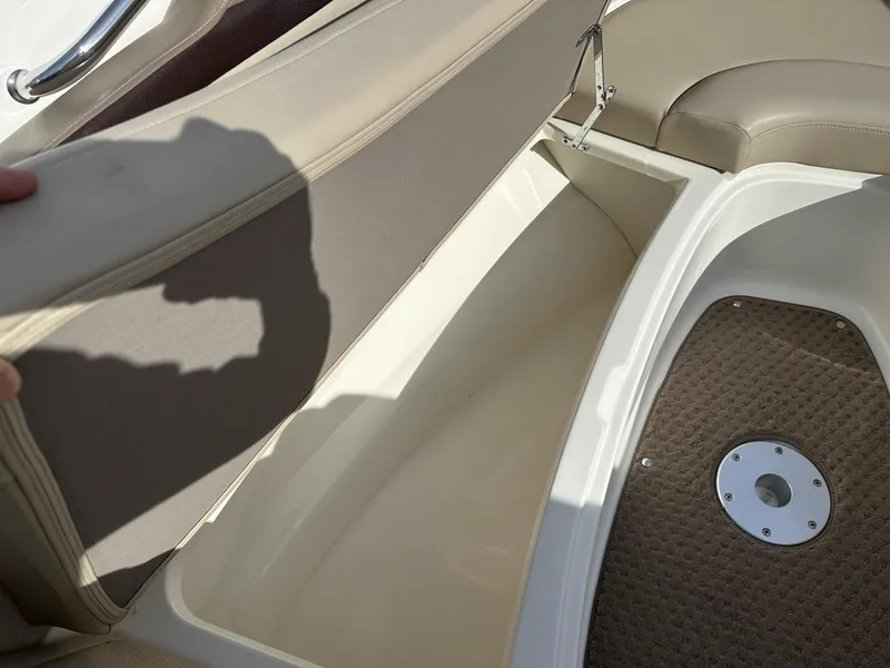 Slide: The Image of 2011 Sea Ray 250 SLX boat interior storage compartment with beige seating and carpeted floor. - 11