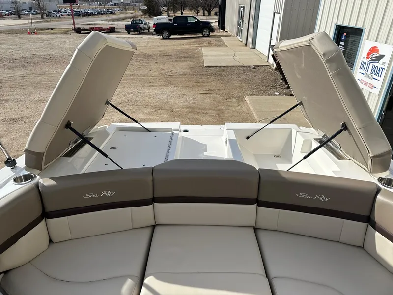 Slide: The Image of 2011 Sea Ray 250 SLX boat with open storage compartments and cushioned seating. - 13