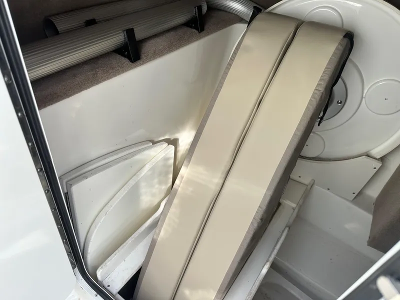 Slide: The Image of 2011 Sea Ray 250 SLX interior storage compartment with cushions and accessories. - 14