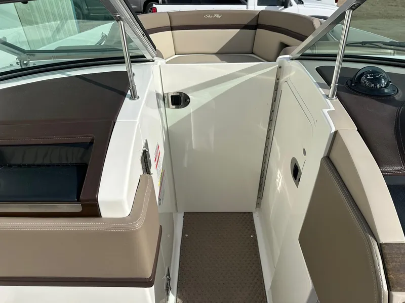 Slide: The Image of 2011 Sea Ray 250 SLX boat interior with beige seating and dashboard. - 19