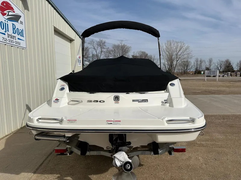 Slide: The Image of Rear view of a 2011 Sea Ray 250 SLX boat with black cover, parked outdoors. - 35