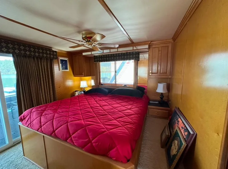 Slide: The Image of Cozy bedroom in 2006 Lakeview 16x68 houseboat with red bedding and wooden paneling. - 10