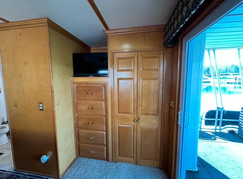 Slide: The Image of Interior of 2006 Lakeview 16x68 houseboat with wooden cabinets and a TV. - 11