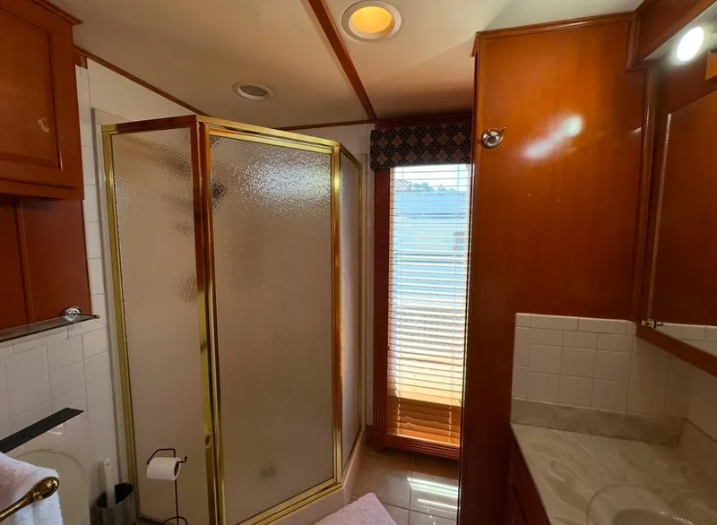 Slide: The Image of Bathroom in 2006 Lakeview 16x68 houseboat with shower, wooden cabinets, and natural light. - 12
