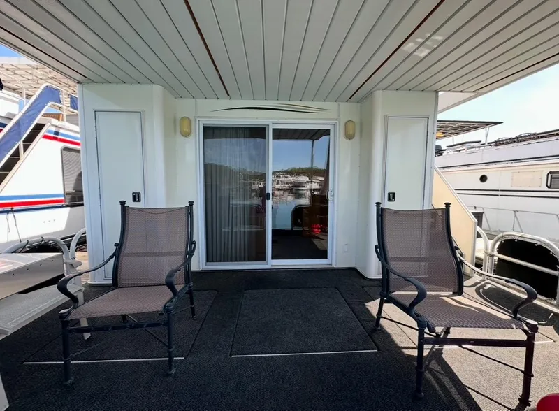 Slide: The Image of Outdoor deck of 2006 Lakeview 16x68 houseboat with chairs and sliding glass door. - 13