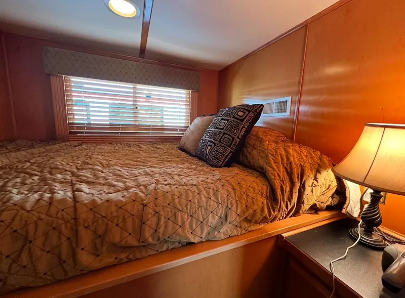 Slide: The Image of Cozy bedroom in 2006 Lakeview 16x68 houseboat with warm lighting and wooden interior. - 6
