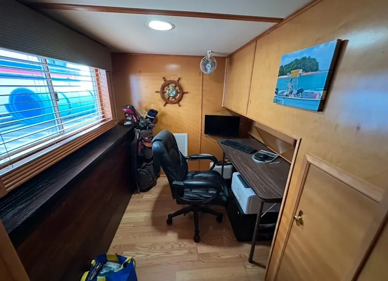 Slide: The Image of Office space inside a 2006 Lakeview 16x68 houseboat with desk, chair, and golf clubs. - 8