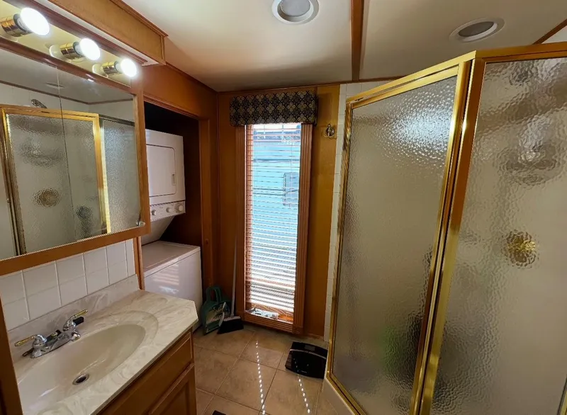 Slide: The Image of Bathroom in 2006 Lakeview 16x68 with shower, vanity, and stacked washer-dryer. - 9