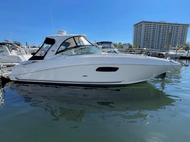 The Image of 2011 Sea Ray 370 Sundancer yacht docked in marina, clear blue sky background. - 0