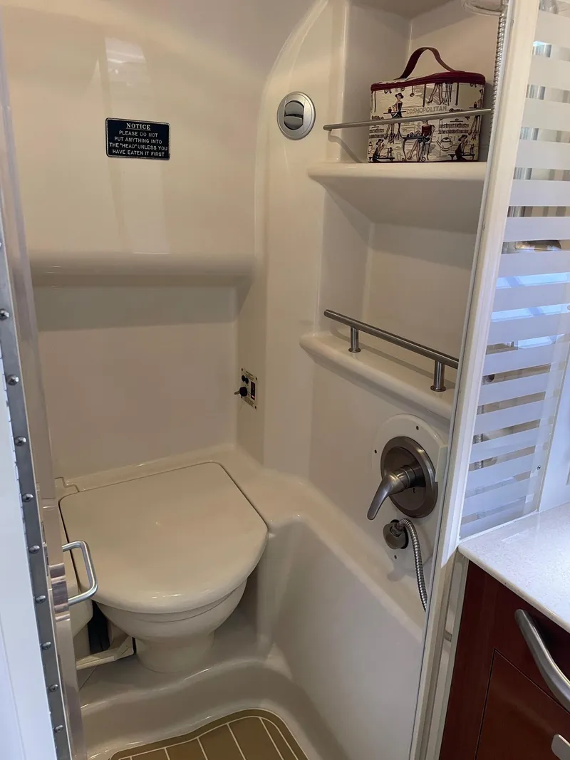 Slide: The Image of Interior of 2011 Sea Ray 370 Sundancer with beige sofa, colorful pillows, and wooden cabinetry. - 21