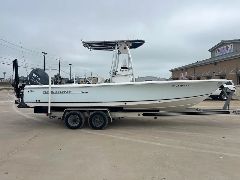 Slide: The Image of 2009 Sea Hunt BX24 boat on trailer, parked at a marina with Yamaha engine. - 10