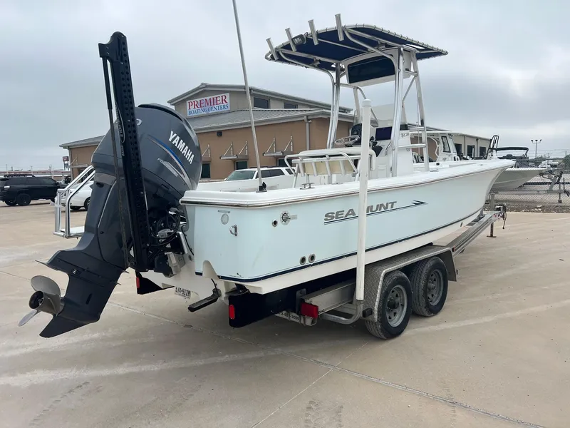 Slide: The Image of 2009 Sea Hunt BX24 boat on trailer with Yamaha outboard motor, parked outdoors. - 11