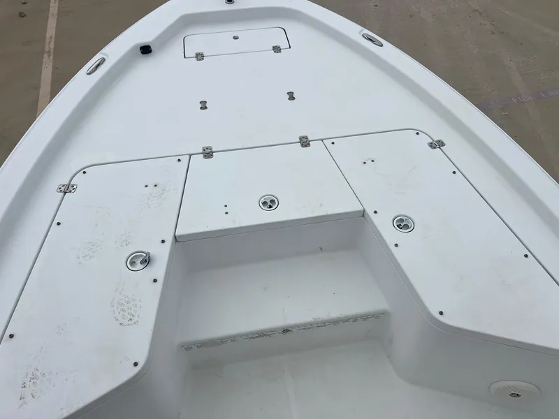 Slide: The Image of 2009 Sea Hunt BX24 boat deck with storage compartments and clean white surface. - 15