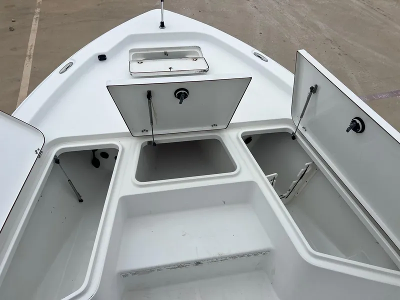 Slide: The Image of 2009 Sea Hunt BX24 boat storage compartments open on deck. - 16