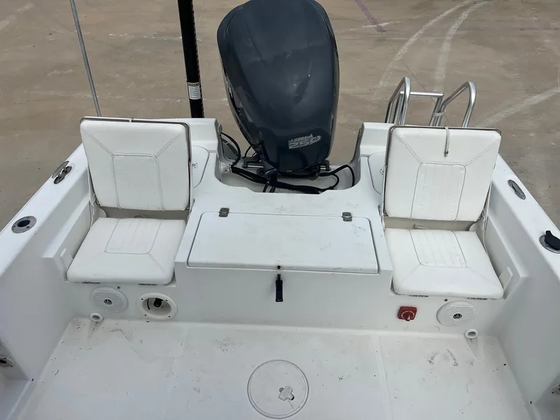 Slide: The Image of 2009 Sea Hunt BX24 boat interior with white seating and motor. - 29