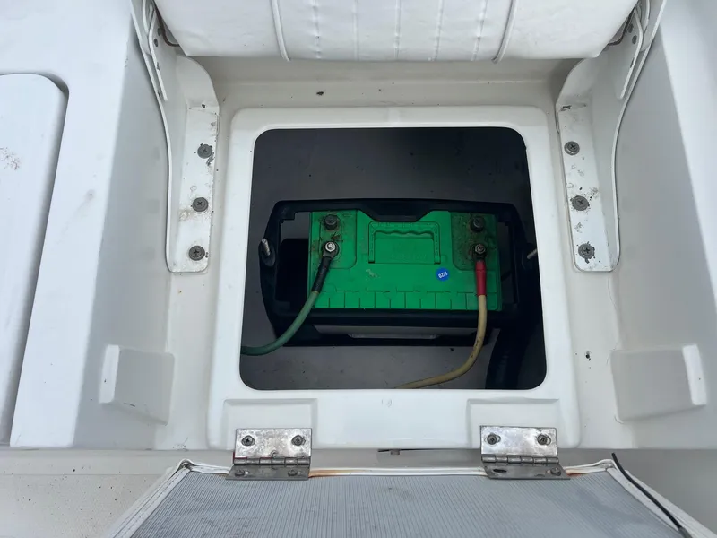 Slide: The Image of Battery compartment of a 2009 Sea Hunt BX24 boat, featuring a green marine battery. - 31