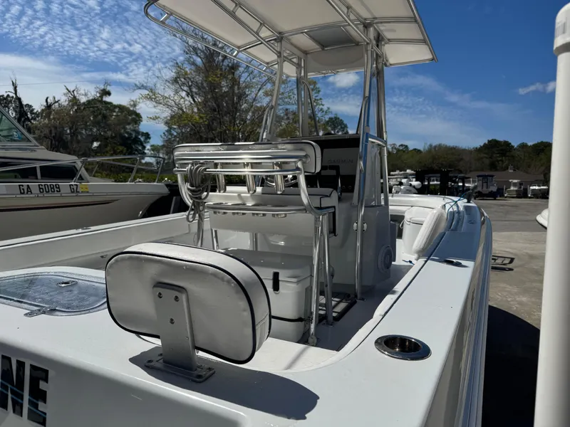 Slide: The Image of 2015 Contender 24 Sport boat with T-top and seating, docked under a clear blue sky. - 11