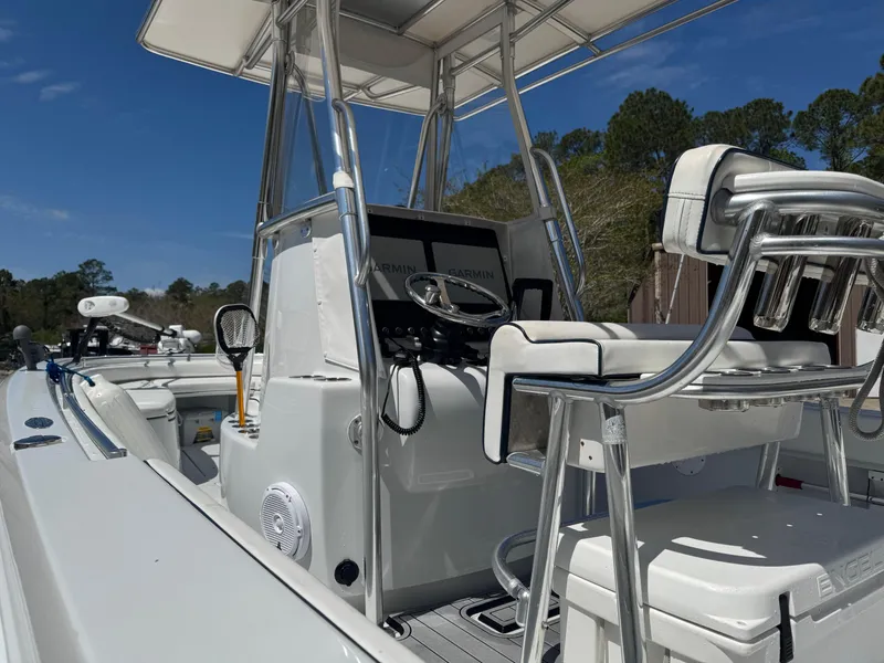 Slide: The Image of 2015 Contender 24 Sport boat interior with steering console and seating under a clear blue sky. - 12