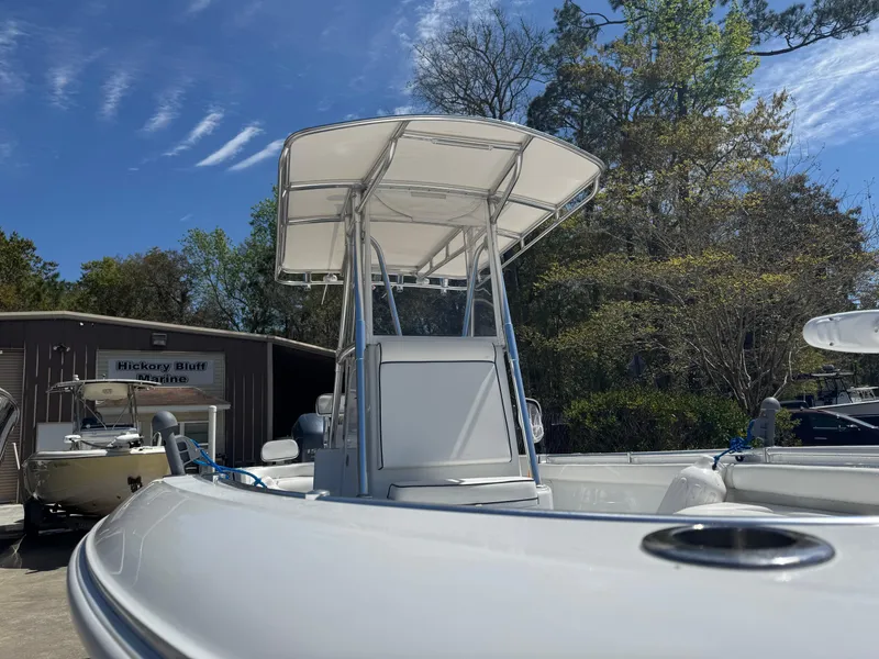 Slide: The Image of 2015 Contender 24 Sport boat with T-top, parked outdoors under a clear sky. - 16