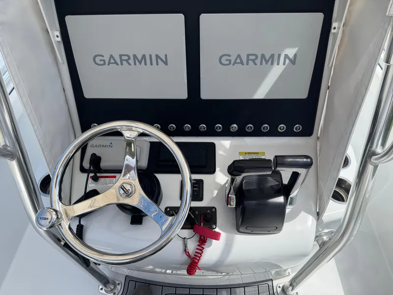 Slide: The Image of 2015 Contender 24 Sport boat dashboard with Garmin displays and steering wheel. - 23