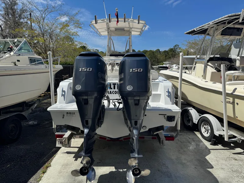 Slide: The Image of 2015 Contender 24 Sport boat with twin 150 horsepower engines, docked outdoors. - 27