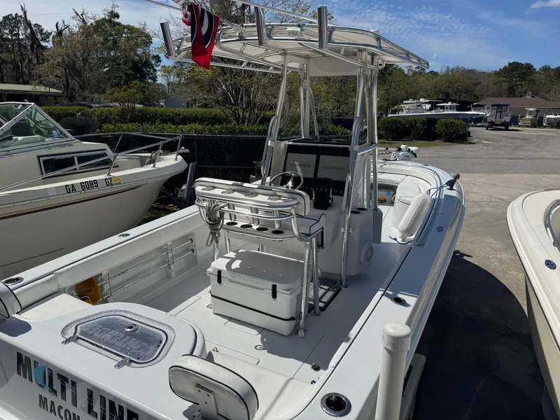 Slide: The Image of 2015 Contender 24 Sport boat with center console and T-top in a marina setting. - 29