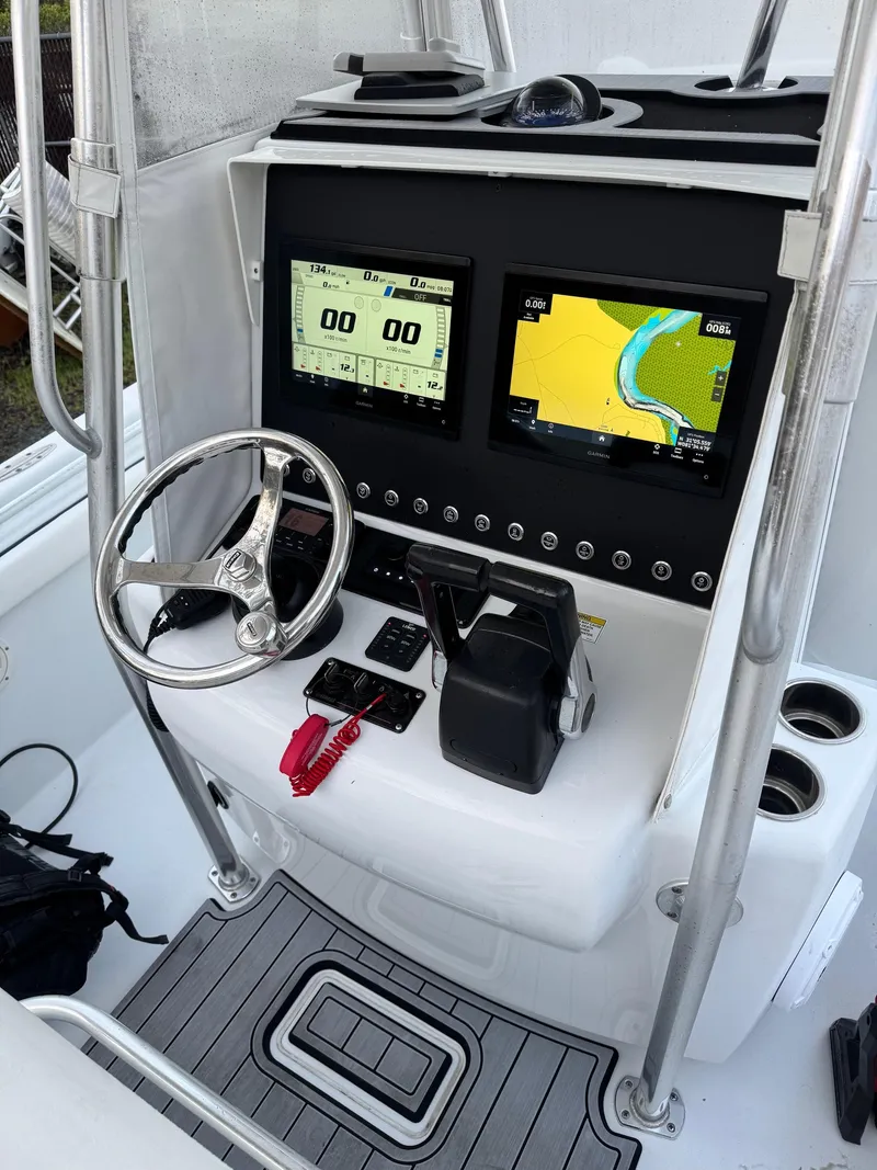 Slide: The Image of 2015 Contender 24 Sport boat console with steering wheel and navigation screens. - 7