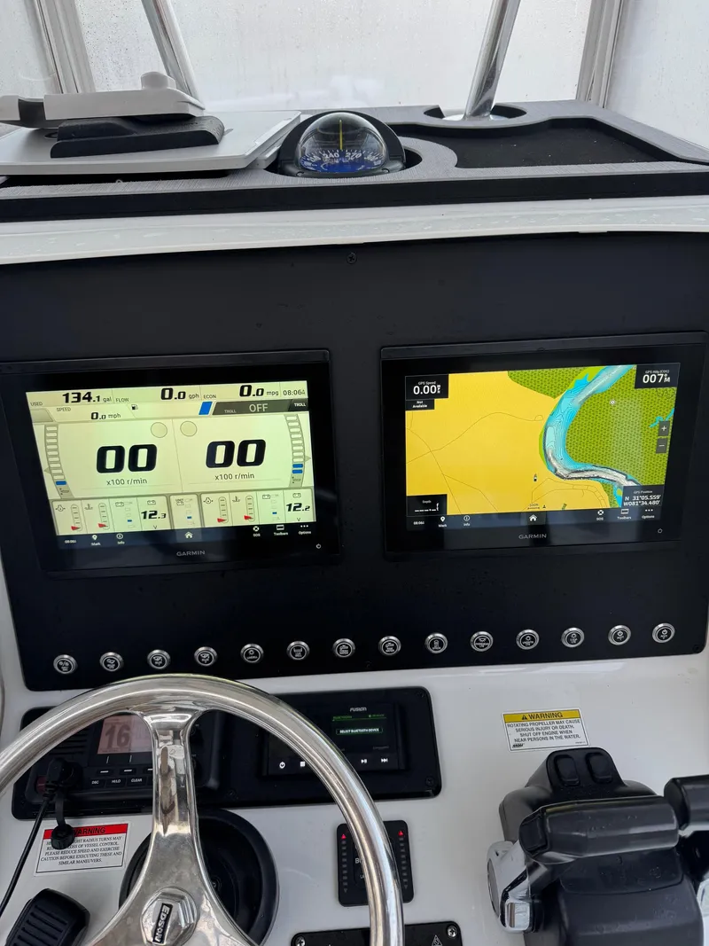 Slide: The Image of Dashboard of a 2015 Contender 24 Sport boat with navigation screens and controls. - 9