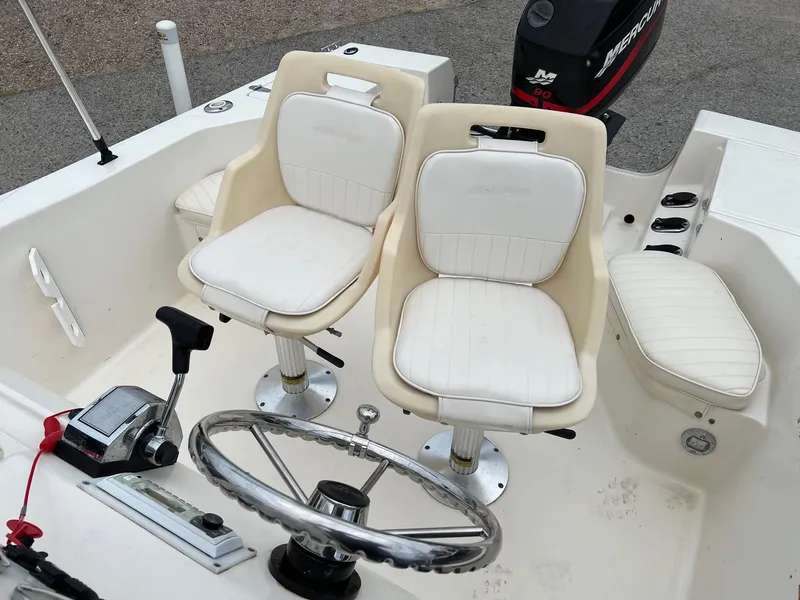 Slide: The Image of 2000 Sea Pro 180 Center Console boat interior with dual white seats and steering wheel. - 10