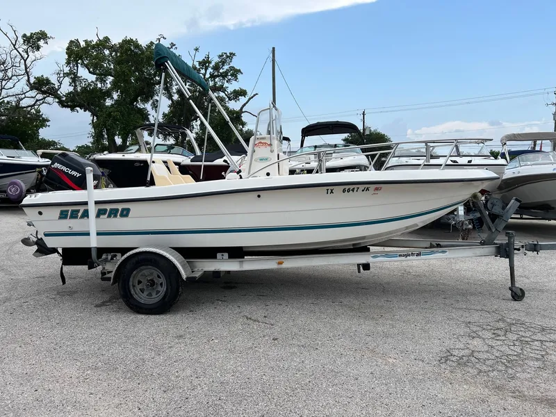 Slide: The Image of 2000 Sea Pro 180 Center Console boat on trailer, parked in a marina lot. - 2