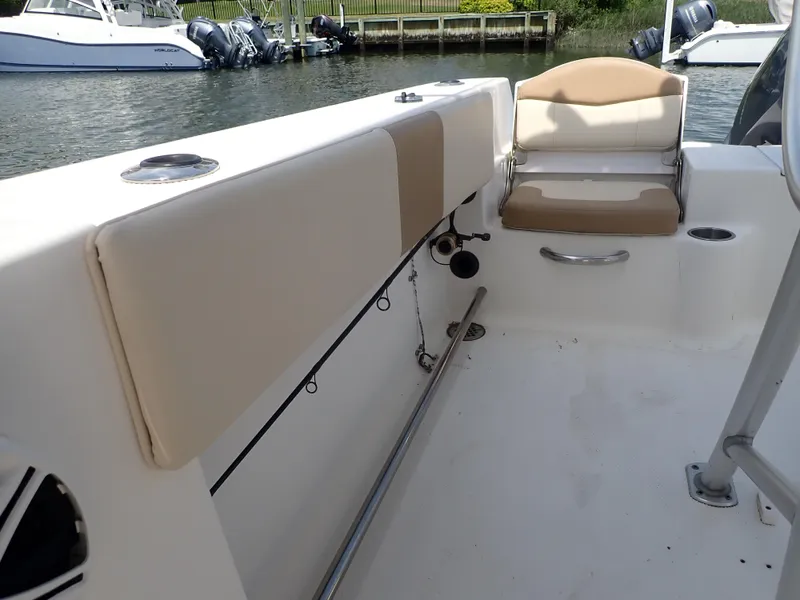 Slide: The Image of 2014 Robalo R200 Center Console boat interior with beige seating and rod holders. - 18