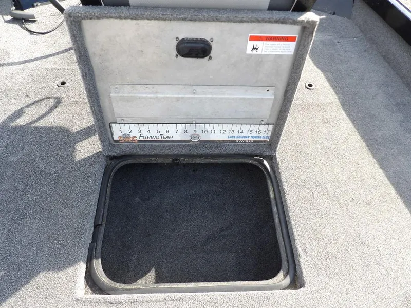 Slide: The Image of 2013 Crestliner TC Series 18 boat storage compartment with measuring ruler on lid. - 31