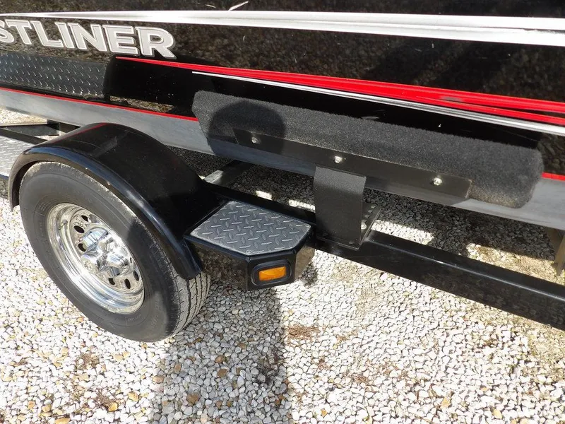 Slide: The Image of 2013 Crestliner TC Series 18 trailer with black fender and chrome wheel on gravel. - 38