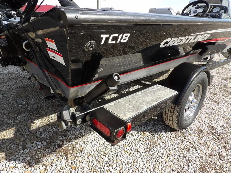 Slide: The Image of 2013 Crestliner TC Series 18 boat on trailer, featuring black exterior and red accents. - 40