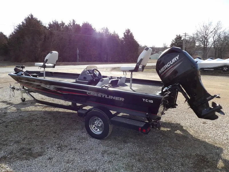 Slide: The Image of 2013 Crestliner TC Series 18 boat with Mercury outboard motor, parked on gravel. - 5