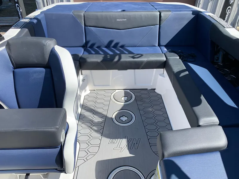Slide: The Image of 2023 MasterCraft NXT20 boat interior with blue and gray seating and hexagonal floor design. - 14
