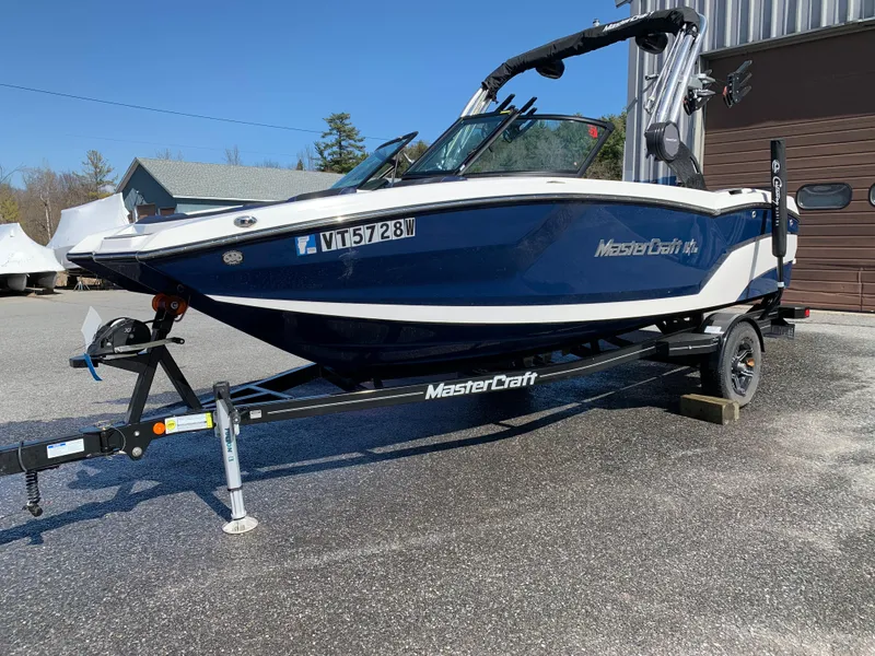 Slide: The Image of 2023 MasterCraft NXT20 boat on trailer, parked outdoors. - 3