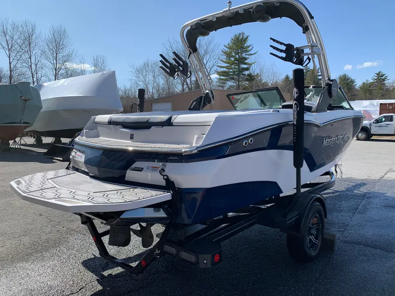 Slide: The Image of 2023 MasterCraft NXT20 boat on trailer, rear view, outdoors, clear sky. - 8
