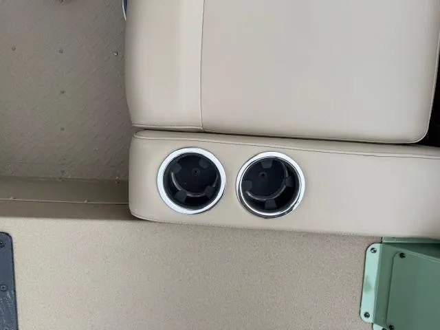 Slide: The Image of 2025 SeaArk Easy 200 boat interior with dual cup holders and beige seating. - 19