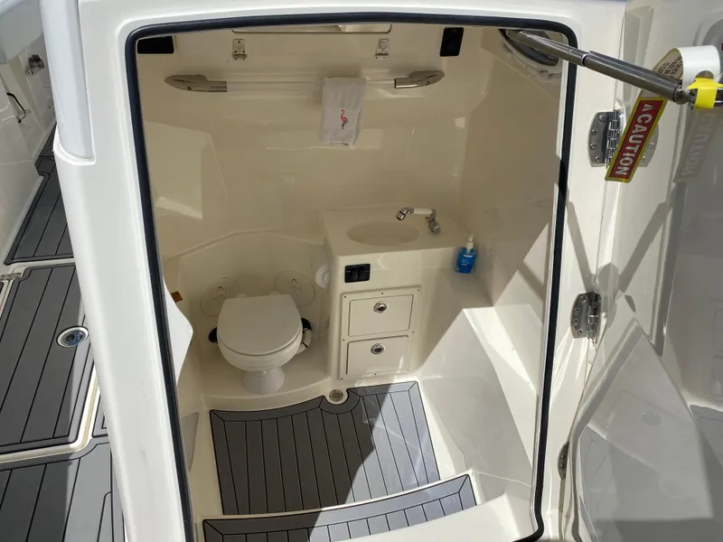 Slide: The Image of 2022 Cobia 301 Center Console boat interior with toilet and sink. - 11