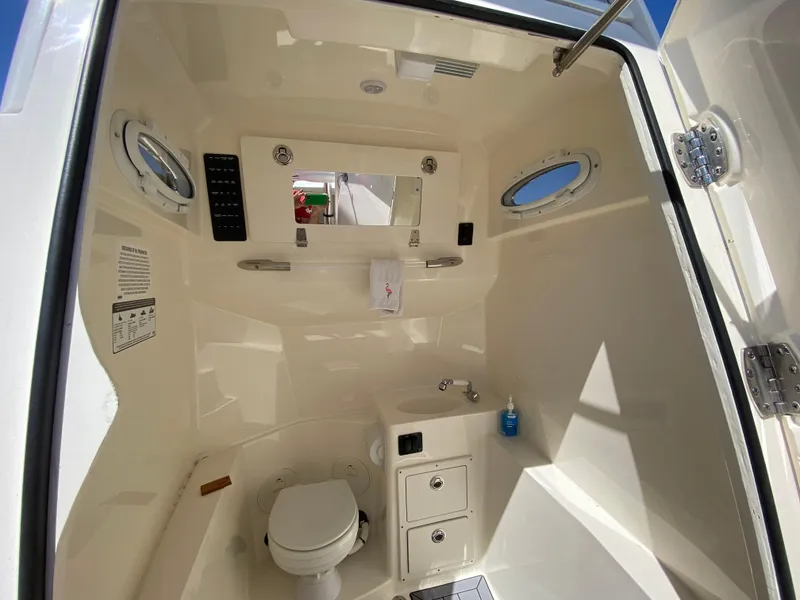Slide: The Image of 2022 Cobia 301 Center Console boat interior with toilet and sink. - 12