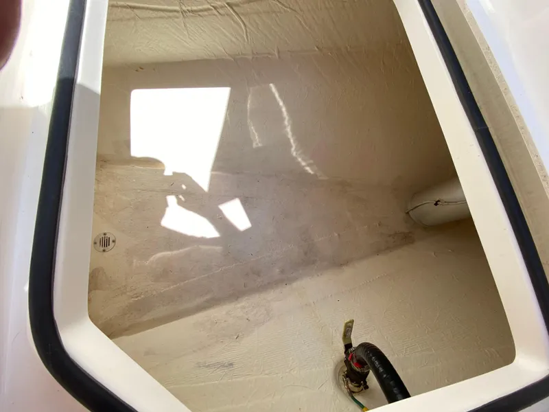 Slide: The Image of 2022 Cobia 301 Center Console storage compartment interior view. - 16