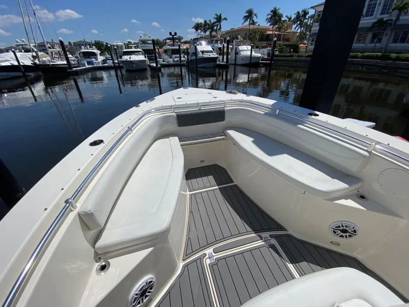 Slide: The Image of 2022 Cobia 301 Center Console boat with spacious seating at a marina. - 20