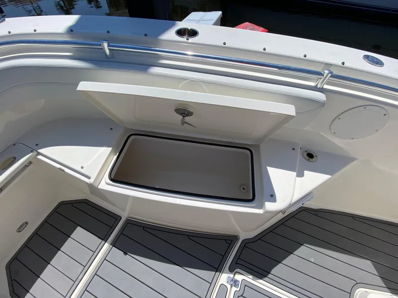 Slide: The Image of 2022 Cobia 301 Center Console boat with open storage compartment and sleek deck design. - 22