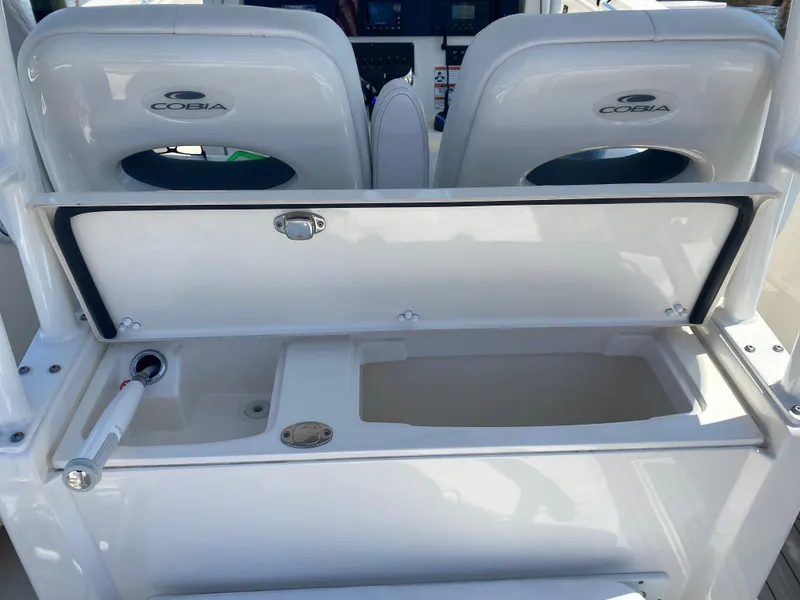 Slide: The Image of 2022 Cobia 301 Center Console boat with open storage compartment and dual seats. - 27
