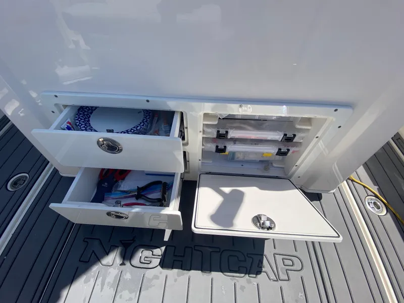Slide: The Image of 2022 Cobia 301 Center Console storage compartments with open drawers and tackle boxes. - 30