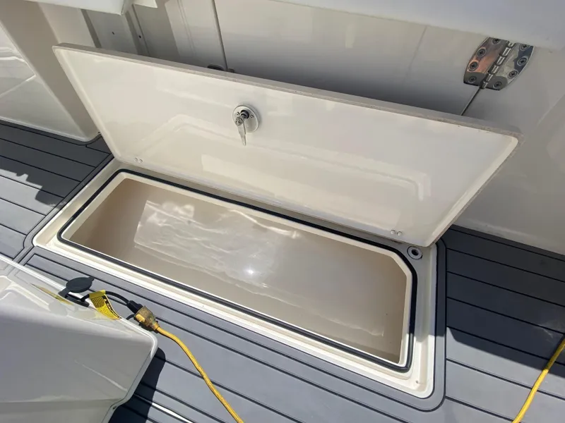 Slide: The Image of Open storage compartment on 2022 Cobia 301 Center Console boat deck. - 31